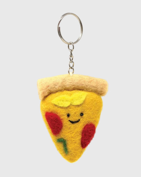 A felt pizza slice keychain with a smiling face, featuring yellow cheese, red tomato spots, a beige crust, and a silver metal key ring on a plain white background.