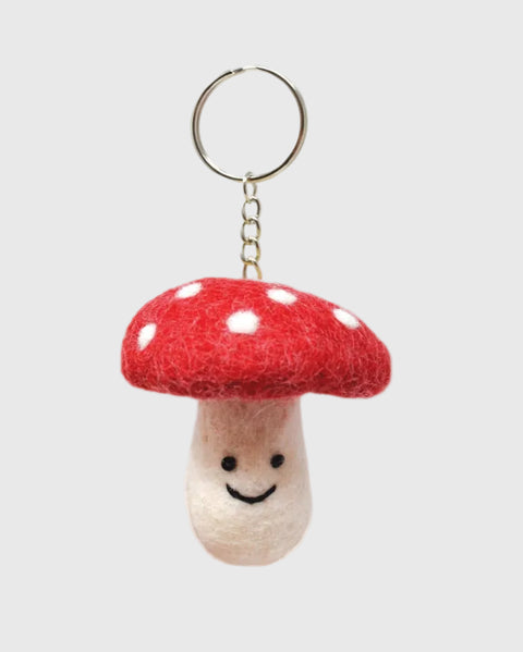 Mushroom-shaped keychain with a red cap and white spots on a white background
