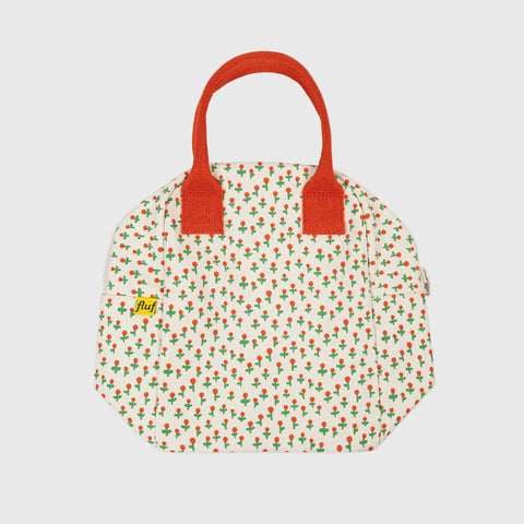 Floral-patterned bag with red handles on a white background