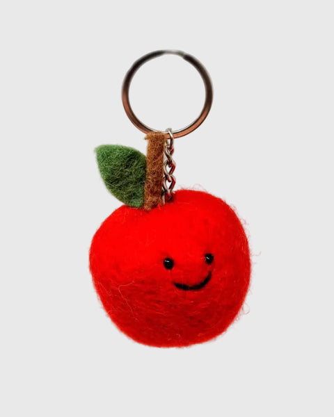 Red apple-shaped keychain with a smiley face on a white background
