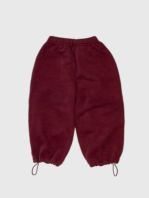 Maroon pants with drawstring on a light gray background