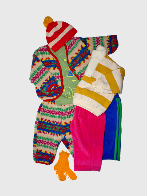 Colorful baby outfit with a hat, onesie, and socks on a light gray background