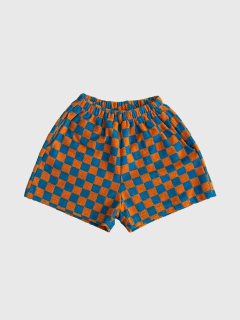 Checkered shorts with orange and blue pattern on a light gray background