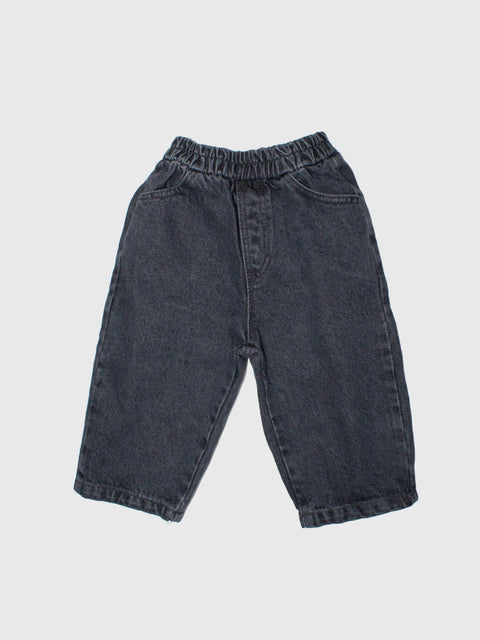 Dark blue denim pants on a light gray background