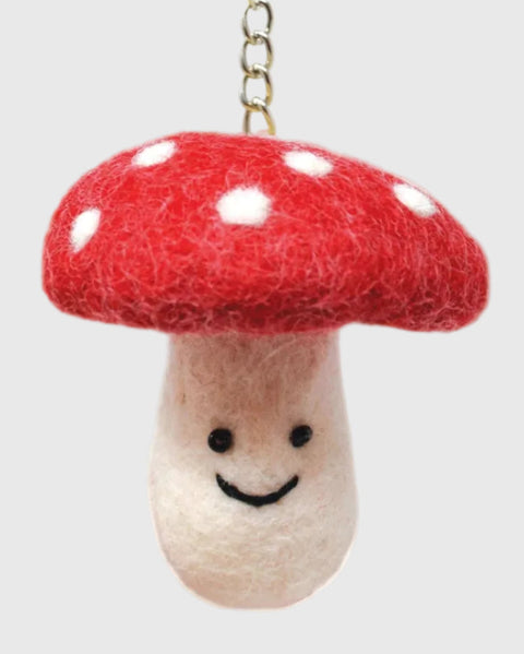 Mushroom-shaped keychain with a red cap and beige stem on a white background